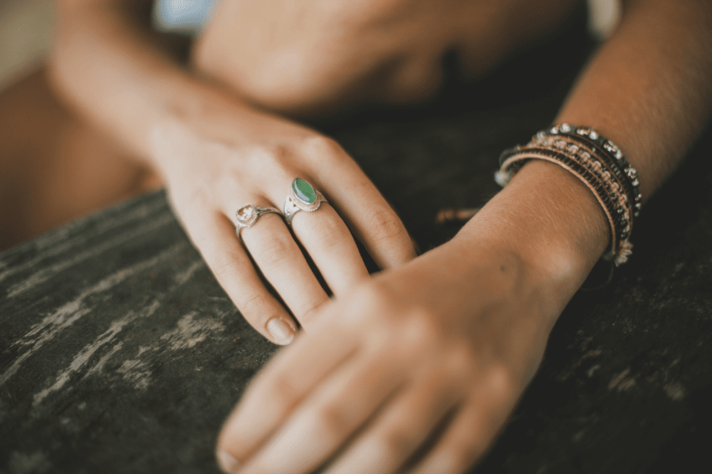 manos de mujer con anillos y pulseras de bisutería