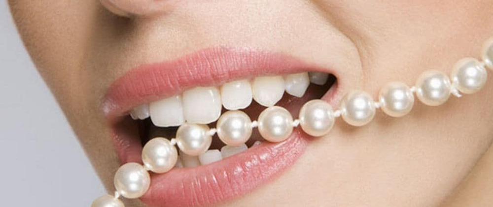 mujer haciendo la prueba de los dientes para identificar perlas naturales