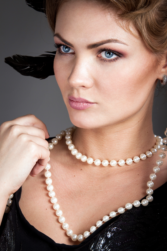 mujer con collares de perlas