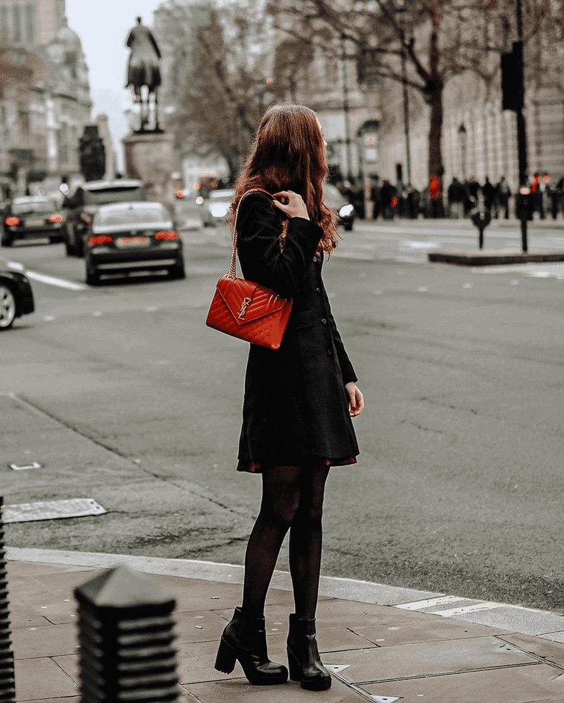 mujer con bolso rojo y botas negras