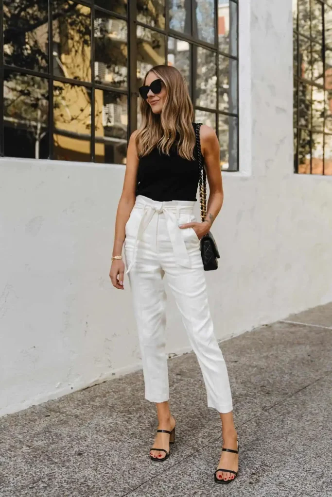 mujer con pantalon blanco y top negro